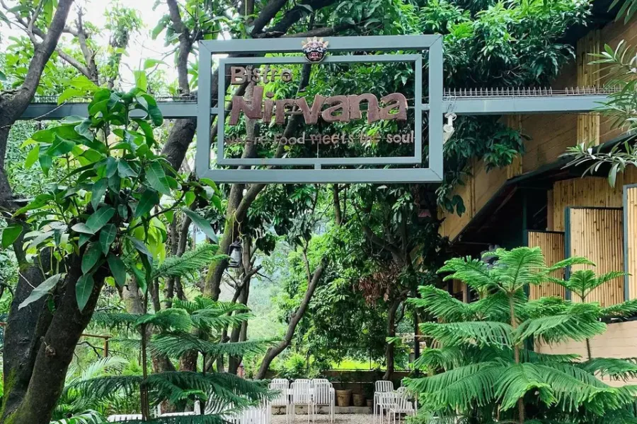 Bistro Nirvana sign and leafy garden entrance in Tapovan, Rishikesh