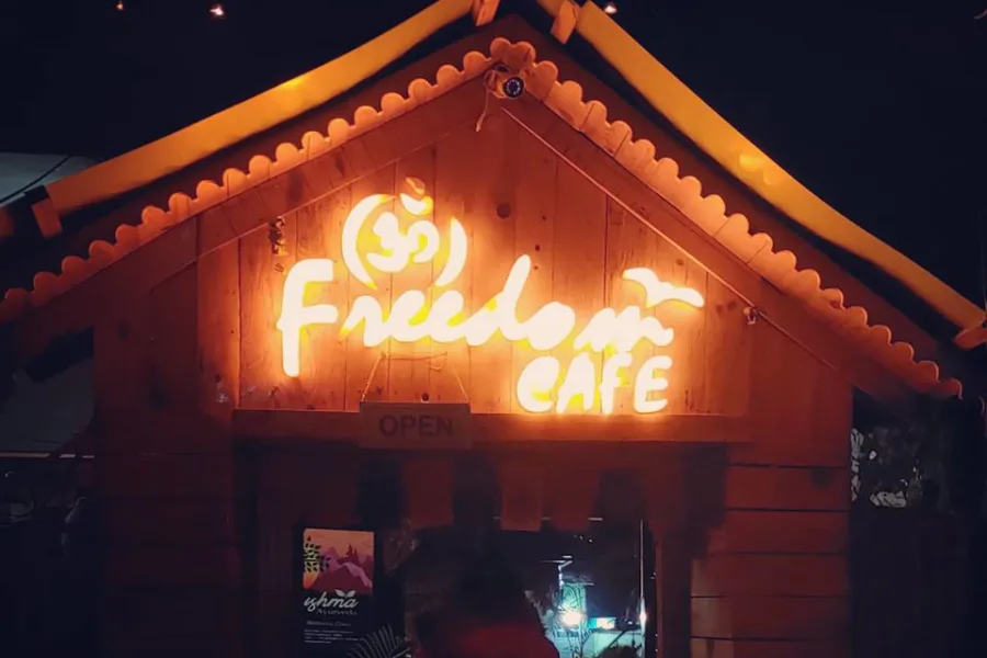 Illuminated Om Freedom Cafe entrance sign in Rishikesh